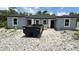 Construction site with a dumpster in front of a new build with gray facade and dark roof at 17099 Carleen Ave, Port Charlotte, FL 33948