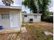 Close up of backyard featuring mature trees, a lush lawn, and a home with a white door at 1906 E 98Th Ave, Tampa, FL 33612
