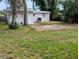 Back of home featuring large backyard, grass, concrete slab, and external AC unit at 1906 E 98Th Ave, Tampa, FL 33612