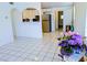 Open-concept living space with tile floors, an archway to the kitchen and white walls at 1906 E 98Th Ave, Tampa, FL 33612
