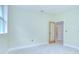 A well-lit bedroom with light green walls, light tile flooring, and view into hall at 1931 Jaudon Rd, Dover, FL 33527