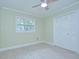 A light-filled bedroom with a ceiling fan, a window with backyard view, and closet at 1931 Jaudon Rd, Dover, FL 33527