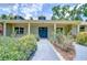 A charming front entrance with lush landscaping and beautiful blue doors at 1931 Jaudon Rd, Dover, FL 33527