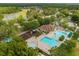 Aerial view of the community pool and playground next to a scenic lake at 26501 Whirlaway Ter, Wesley Chapel, FL 33544