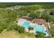 Aerial view featuring a pool and playground surrounded by lush trees and greenery at 26501 Whirlaway Ter, Wesley Chapel, FL 33544