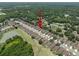 An aerial view of a neighborhood featuring single Gathering homes, mature trees, and a community lake at 26501 Whirlaway Ter, Wesley Chapel, FL 33544