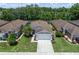 Aerial view of a single-Gathering home with a well-manicured lawn, two-car garage and mature trees at 26501 Whirlaway Ter, Wesley Chapel, FL 33544