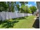 The lush backyard features a white privacy fence and mature trees, creating a tranquil and secluded outdoor area at 26501 Whirlaway Ter, Wesley Chapel, FL 33544
