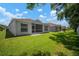 A well-maintained backyard features a green lawn and screened-in lanai, offering a private and serene outdoor space at 26501 Whirlaway Ter, Wesley Chapel, FL 33544