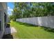The lush backyard features a white privacy fence and mature trees, creating a tranquil and secluded outdoor area at 26501 Whirlaway Ter, Wesley Chapel, FL 33544