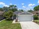 Inviting single-story home boasting a lush front lawn and attached two-car garage at 26501 Whirlaway Ter, Wesley Chapel, FL 33544