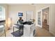 Home office featuring a standup desk, white shelving unit, comfortable chair and plenty of light at 26501 Whirlaway Ter, Wesley Chapel, FL 33544