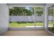 A screened-in lanai provides an unobstructed view of the backyard surrounded by a white fence and lush trees at 26501 Whirlaway Ter, Wesley Chapel, FL 33544