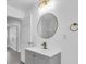 Bathroom features a modern vanity, fixtures, lighting, and round mirror at 2711 E 22Nd Ave, Tampa, FL 33605