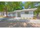Cozy single-story house featuring a gray exterior, a concrete driveway, and complemented by simple landscaping at 2711 E 22Nd Ave, Tampa, FL 33605