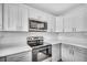 A close-up of stainless steel appliances, white cabinets, and grey counters in the kitchen at 2711 E 22Nd Ave, Tampa, FL 33605