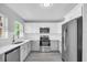 Stylish kitchen featuring stainless steel appliances, white cabinets, and gray flooring at 2711 E 22Nd Ave, Tampa, FL 33605