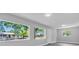 Bright living room with gray walls, wood-look floors, large windows offering outdoor views and recessed lighting at 2711 E 22Nd Ave, Tampa, FL 33605