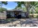 Exterior of the home with a covered patio, picnic table, and mature shade trees at 2721 Baird Ct, Palm Harbor, FL 34684
