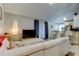 Bright living room with a white sectional sofa, vaulted ceiling, and open to kitchen at 2721 Baird Ct, Palm Harbor, FL 34684