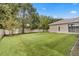 The home has a large backyard with lush grass, trees, and a privacy fence at 3023 Minuteman Ln, Brandon, FL 33511