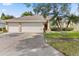 Spacious home with a two-car garage, palm trees and well-maintained landscaping at 3023 Minuteman Ln, Brandon, FL 33511