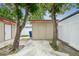 Backyard view featuring detached storage unit surrounded by mature trees at 3324 W Saint Joseph St, Tampa, FL 33607
