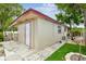 Exterior of home with grass yard and additional outdoor storage unit at 3324 W Saint Joseph St, Tampa, FL 33607