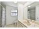 Bright bathroom featuring a marble countertop vanity and tiled shower with a shower curtain at 3324 W Saint Joseph St, Tampa, FL 33607