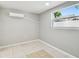 Bedroom with white walls, tiled floors, and an air conditioner at 3324 W Saint Joseph St, Tampa, FL 33607