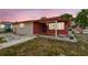 Inviting single story brick and siding home featuring a covered entry, manicured lawn, and American flag at 3324 W Saint Joseph St, Tampa, FL 33607