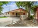 Home exterior with carport, fenced yard, and a mature tree at 3324 W Saint Joseph St, Tampa, FL 33607