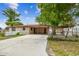 Home exterior with carport, fenced yard, and mature trees on a sunny day at 3324 W Saint Joseph St, Tampa, FL 33607