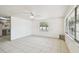 Sunlit living room featuring tile floors, a ceiling fan, and large windows with security bars at 3324 W Saint Joseph St, Tampa, FL 33607