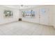 Bright living room featuring tiled floors, ample natural light from windows and a entry door at 3324 W Saint Joseph St, Tampa, FL 33607