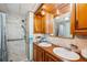 Bathroom featuring double sinks, wood paneling and a convenient walk-in shower at 37105 Lois Ave, Zephyrhills, FL 33542