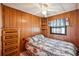 Wood-paneled bedroom, complemented by a ceiling fan, and inviting natural light at 37105 Lois Ave, Zephyrhills, FL 33542