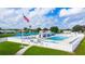 Beautiful community pool area with lounge chairs, clear blue water, an American flag and clear skies at 37105 Lois Ave, Zephyrhills, FL 33542