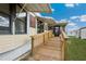Charming home exterior with a ramp leading to the screened-in porch under the awning at 37105 Lois Ave, Zephyrhills, FL 33542