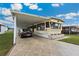 Single-story home with covered parking, featuring a well-manicured lawn and charming flower bed at 37105 Lois Ave, Zephyrhills, FL 33542