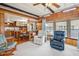 Open-concept living room features wood paneling connecting to kitchen and dining area at 37105 Lois Ave, Zephyrhills, FL 33542