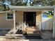 Cozy front porch with covered entrance, a small deck, and a white railing at 3762 18Th S Ter, St Petersburg, FL 33711