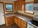 A charming kitchen features wooden cabinets, laminate countertops, and a double basin sink under natural light at 3762 18Th S Ter, St Petersburg, FL 33711