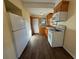 Efficient kitchen showcasing wood cabinetry, appliances, and wood-look flooring offering a practical space at 3762 18Th S Ter, St Petersburg, FL 33711