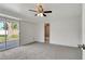 Bright bedroom with neutral carpet, ceiling fan, and sliding glass door to the backyard at 3929 Cochise Ter, Sarasota, FL 34233