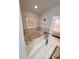 Bright bathroom featuring a large soaking tub and white tiled floor at 5025 Westshore Dr, New Port Richey, FL 34652