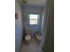 Small restroom with toilet and bidet with a small window at 5025 Westshore Dr, New Port Richey, FL 34652