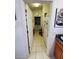 Hallway view into the laundry room, featuring tile flooring and white walls at 5025 Westshore Dr, New Port Richey, FL 34652