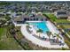 Aerial view of the community pool with palm trees, lounge chairs, and a clubhouse at 5043 White Chicory Dr, Apollo Beach, FL 33572