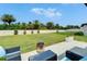 Lush backyard with a privacy fence, palm trees, and a brick patio with seating at 5043 White Chicory Dr, Apollo Beach, FL 33572